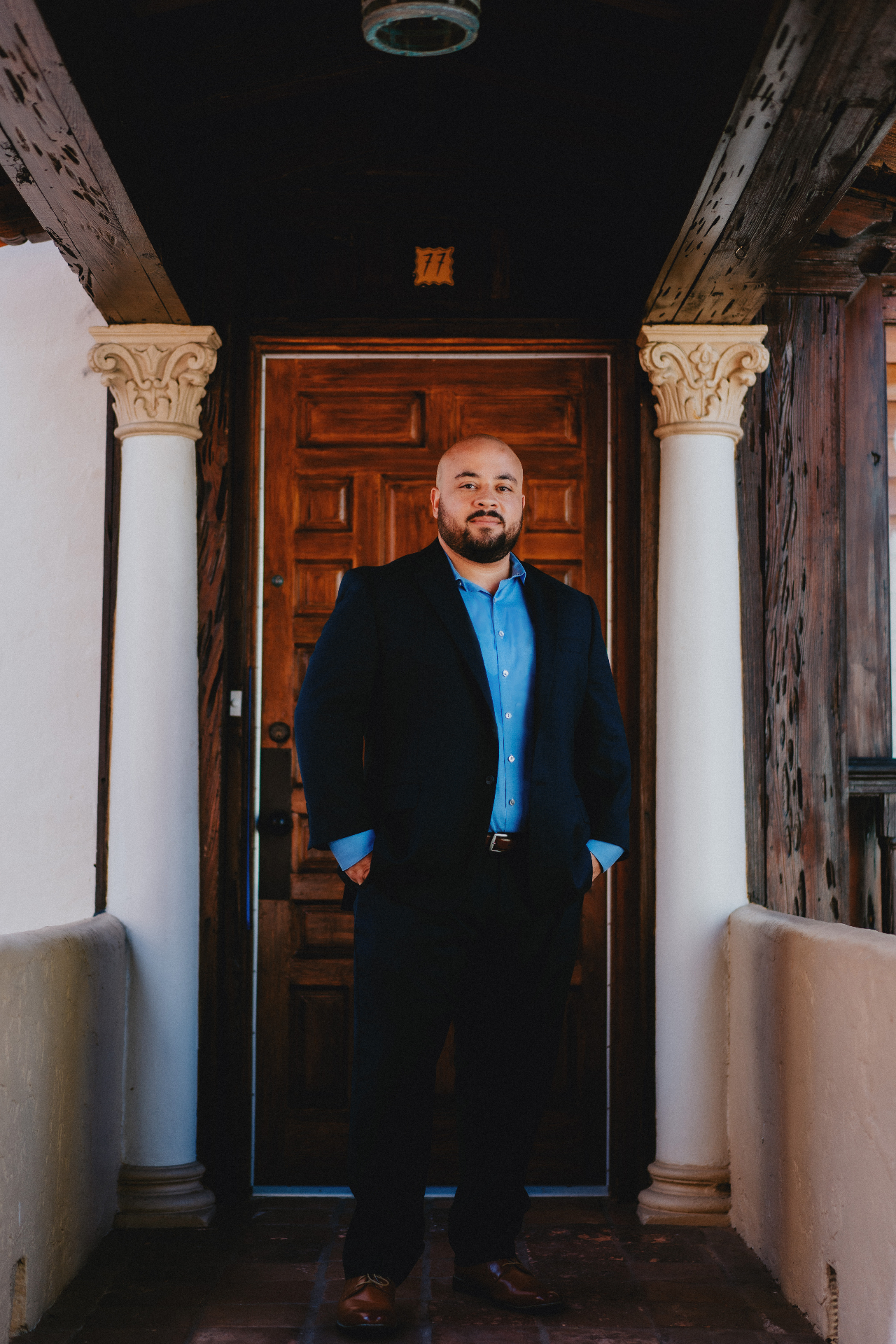 Dr. Santiesteban standing in front of a wooden door